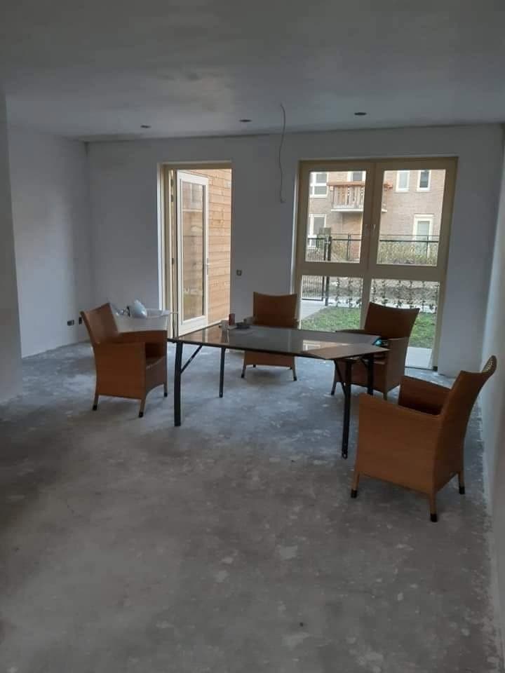 Na: woonkamer met witte wanden en tuindeuren. (Facebook, 10 januari 2021)