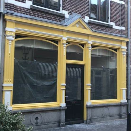 Geel gevelschildering en glas-in-lood ramen