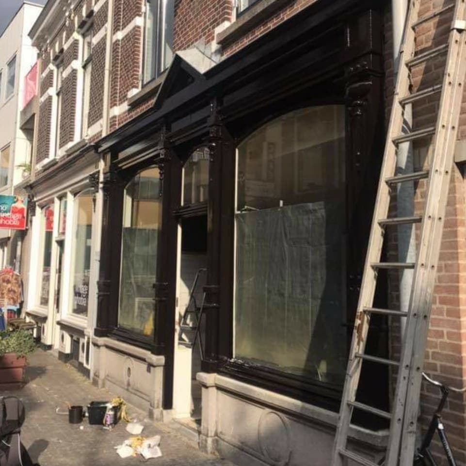 Na, schuin van opzij: pui en sierlijsten in hoogglans, ladder nog tegen de gevel. (jan 2021)