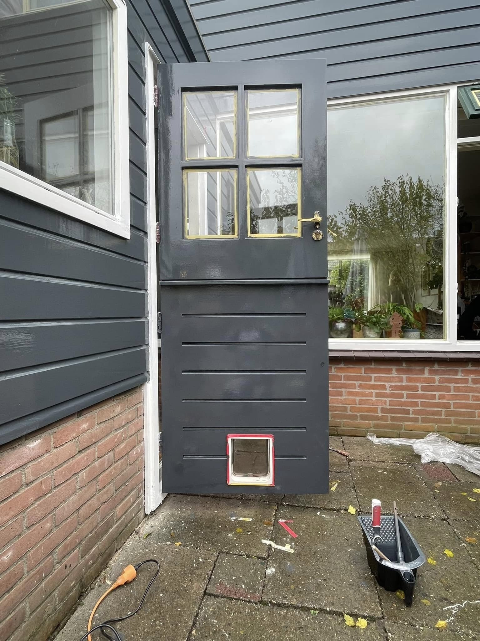 Na: donkere achterdeur met glas in de bovenste helft en een kattenluik onderin. (Facebook, 17 oktober 2024)