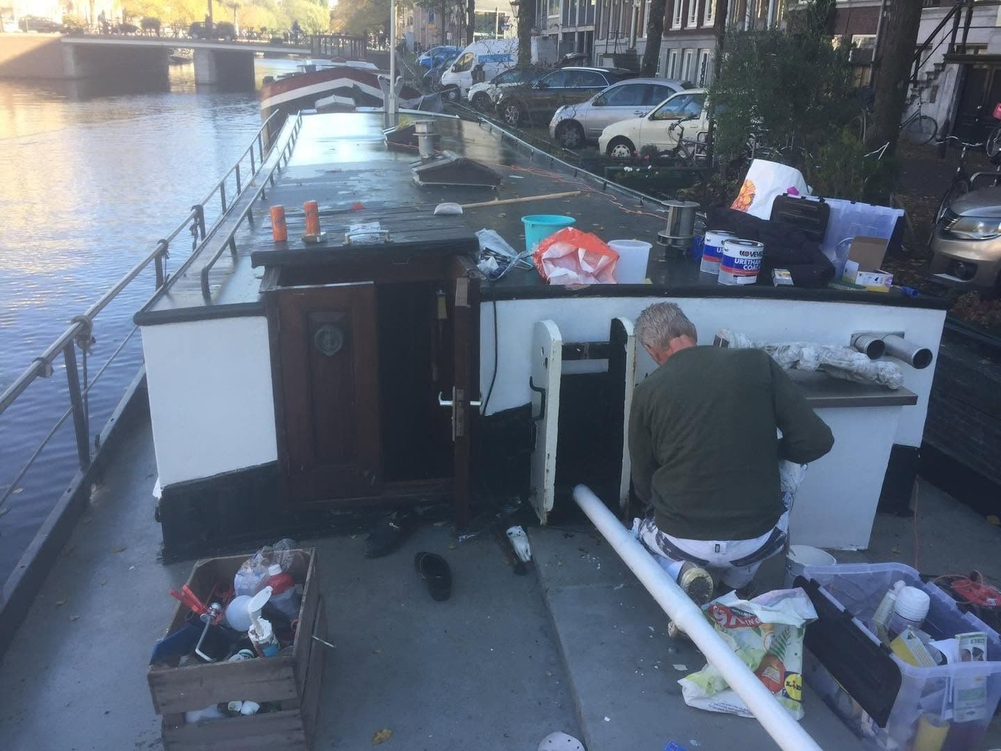 Tijdens het werk: schilder aan het werk bij de opbouw op het dek, met materiaal om zich heen. (Facebook, 13 oktober 2024)