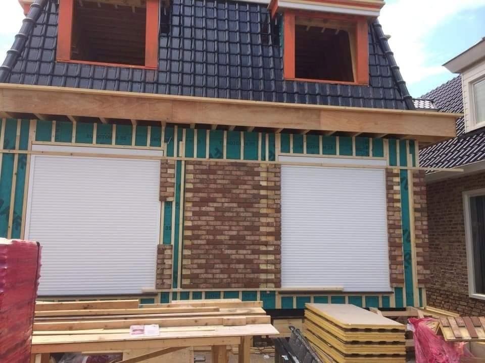 Gevel: de steen wordt tussen het regelwerk aangebracht, de rolluiken zitten erin. (Facebook, 10 januari 2021)