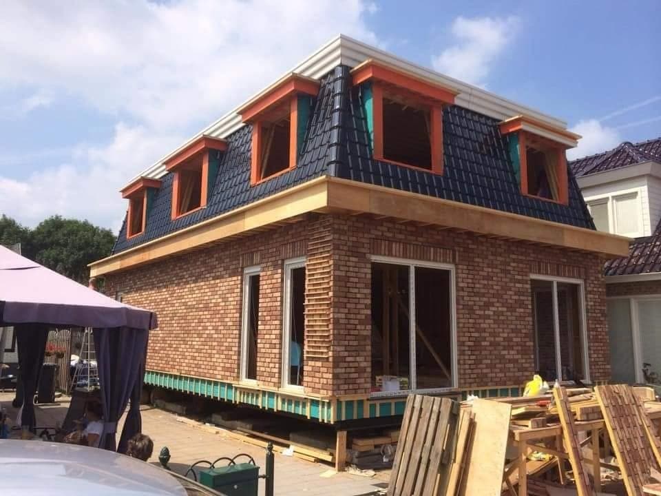 Bijna klaar: hoekaanzicht met de gevel in steen; de dakkapellen zijn nog oranje. (Facebook, 10 januari 2021)