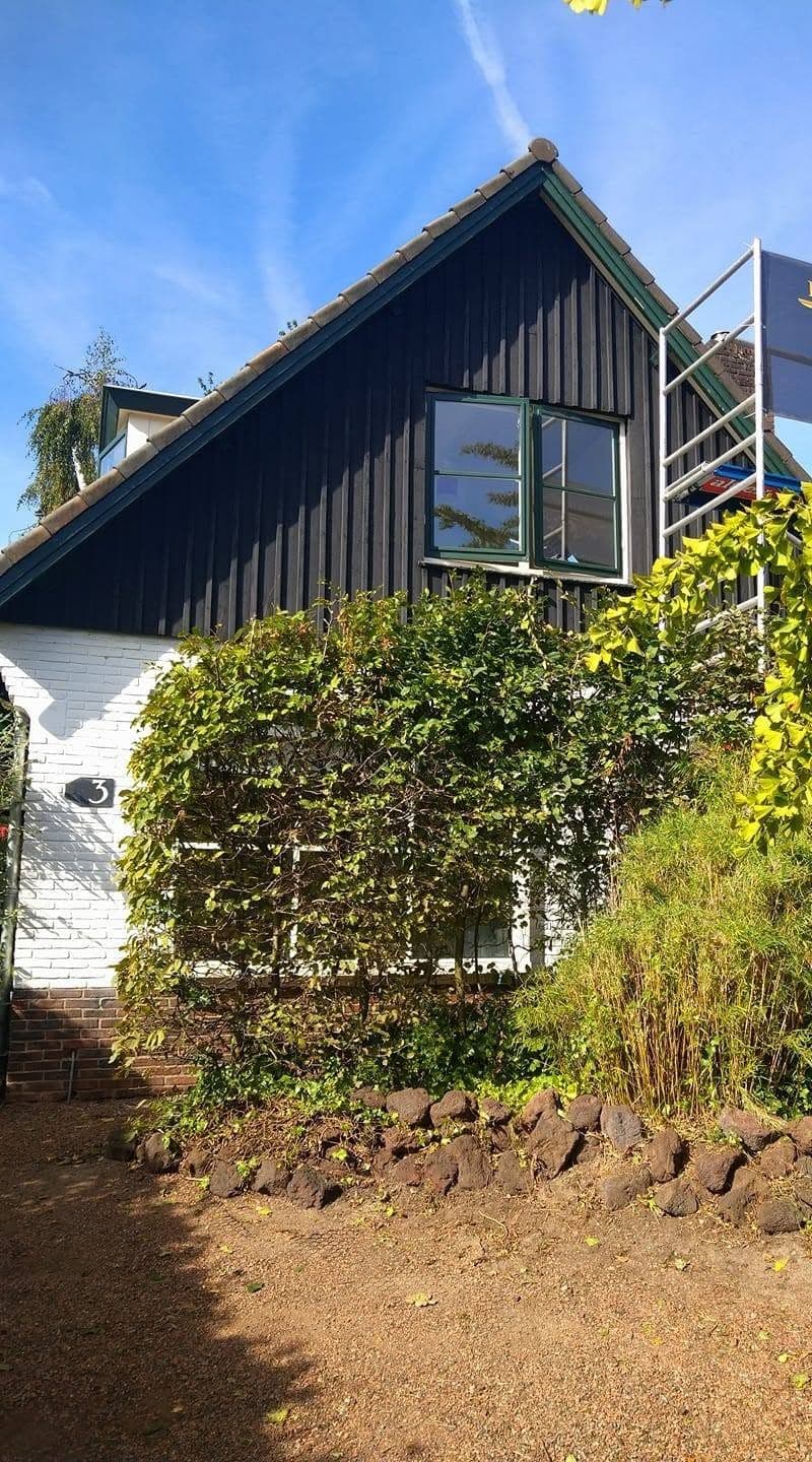 Woning met zwarte houten gevelbekleding, gezien vanuit de tuin. (Facebook, 10 januari 2021)